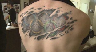 Ripped Skin Olympic Symbol Tattoo On Man Upper Back
