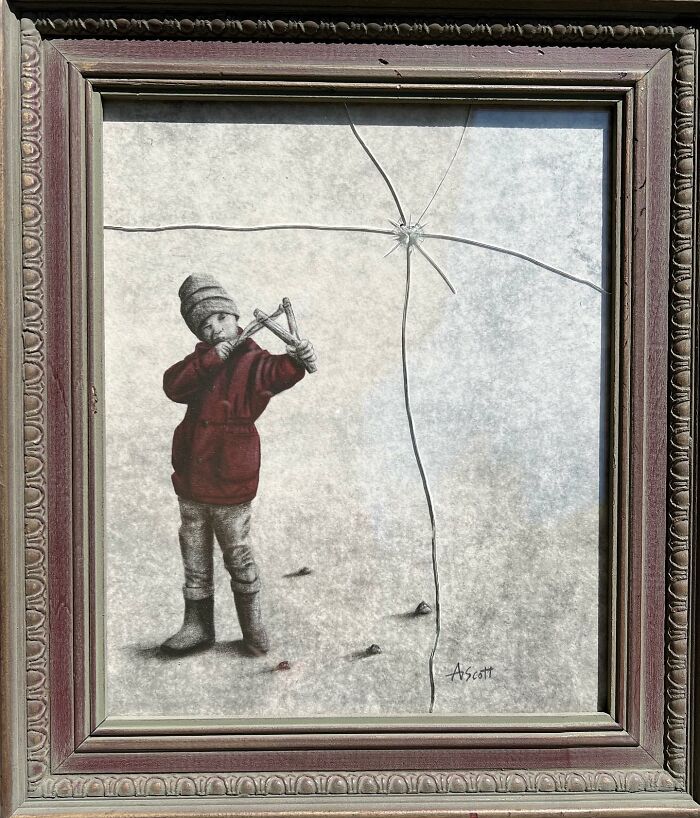 Framed artwork of a vintage-style image with a child playing a trumpet and a cracked glass overlay.