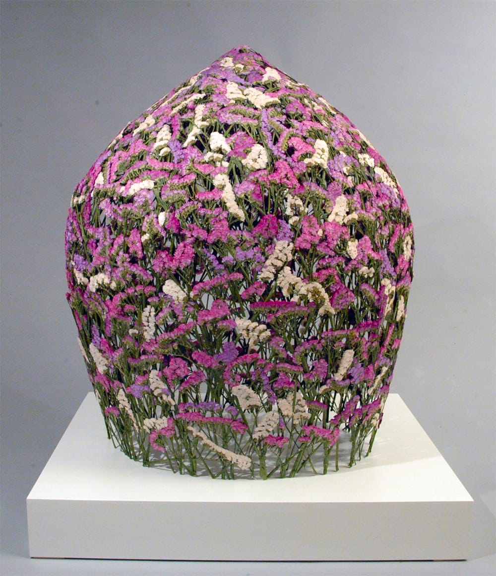 Floral sculpture with pink and white blossoms on display at art exhibition
