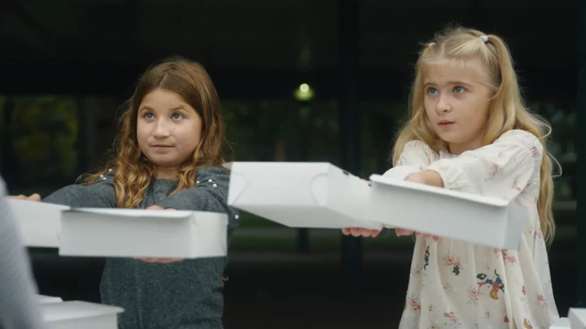 premiações fantasma. Two young girls holding white pizza boxes outdoors looking curious