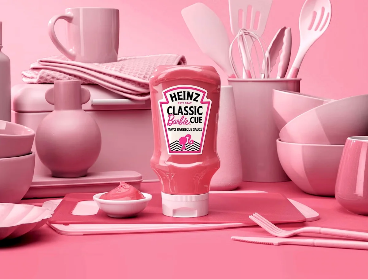 Heinz Classic Barbecue Sauce bottle on pink-themed kitchenware setup including utensils, bowls, and cups.