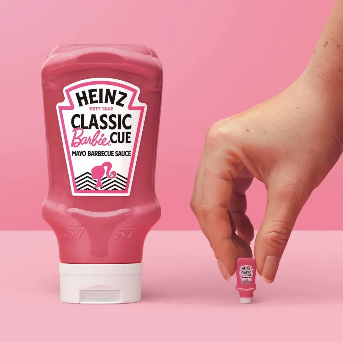Heinz Barbie. 
Heinz Classic BarbieCue Mayo Barbecue Sauce bottle with pink background, showcasing product design and branding alongside a miniature replica.