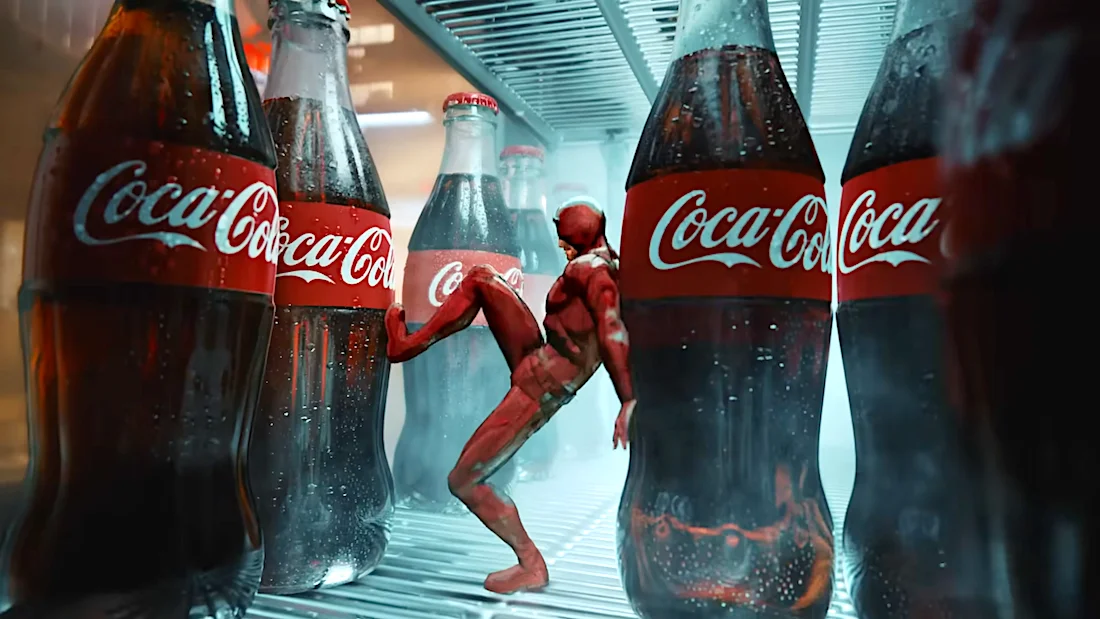 Coca-Cola bottles in a fridge with a Spider-Man figure posing among them.