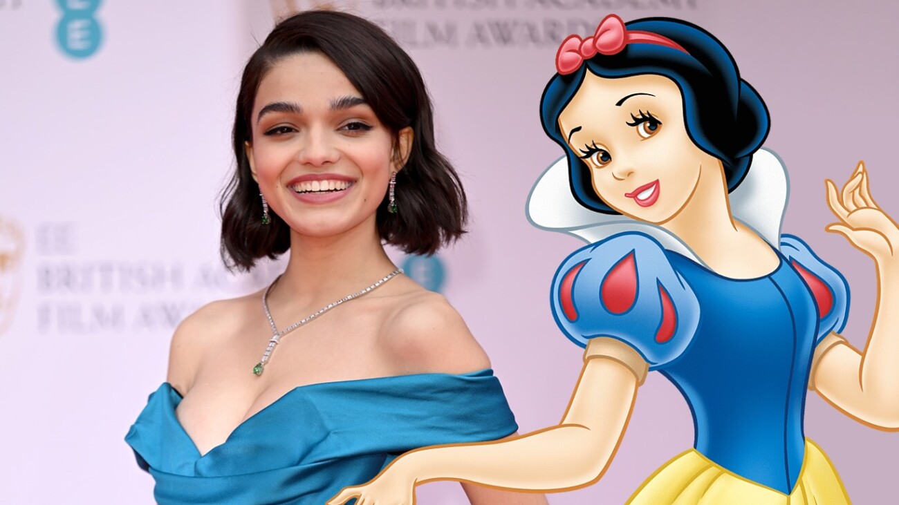 Smiling woman in blue dress on red carpet alongside an illustrated Snow White character. Live-action da Branca de Neve