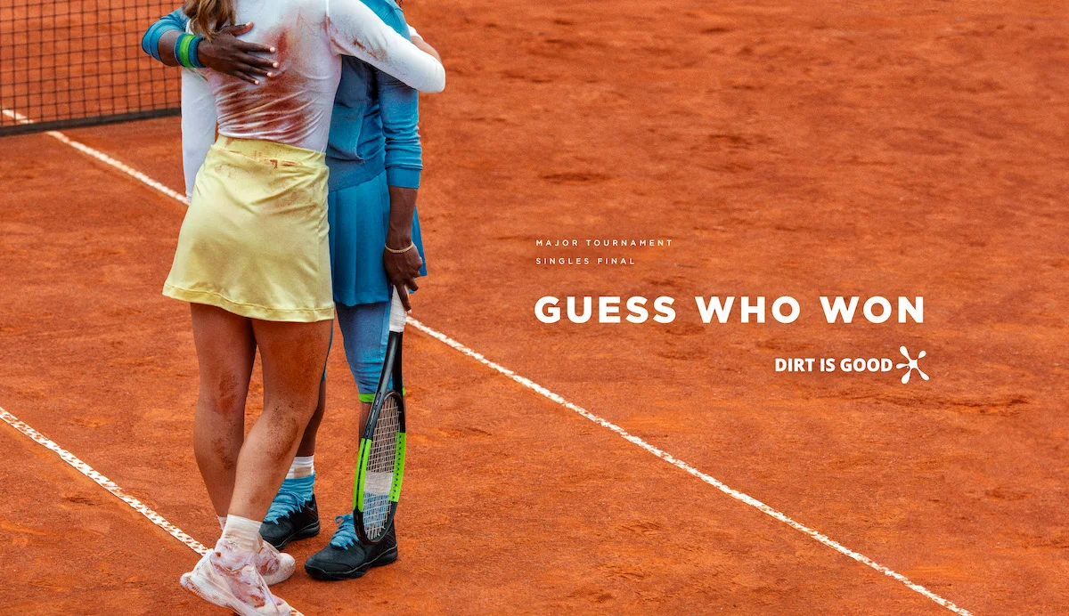 Tennis players embracing on clay court after match with text "Major Tournament Singles Final - Guess Who Won - Dirt is Good"