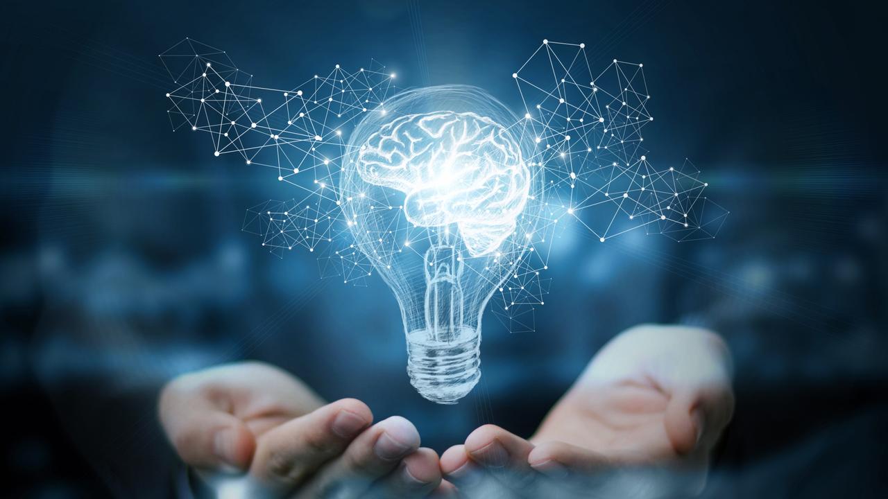 Hands presenting a holographic light bulb with glowing brain network concept on dark background.