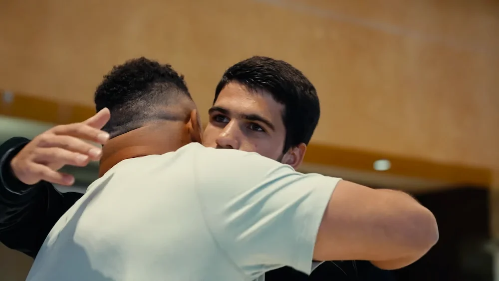 Ronaldo e Alcaraz. Two men embracing in a friendly hug during a social gathering.