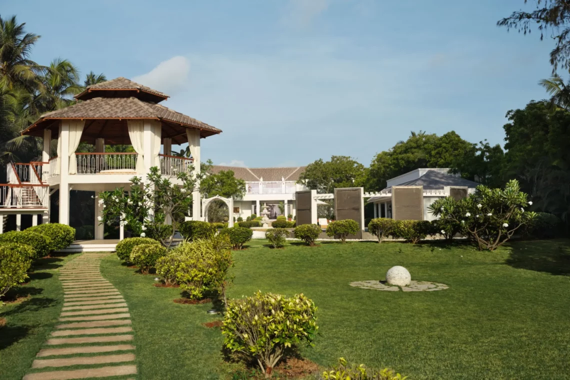 Luxury tropical resort with landscaped gardens and pavilion under clear blue sky
