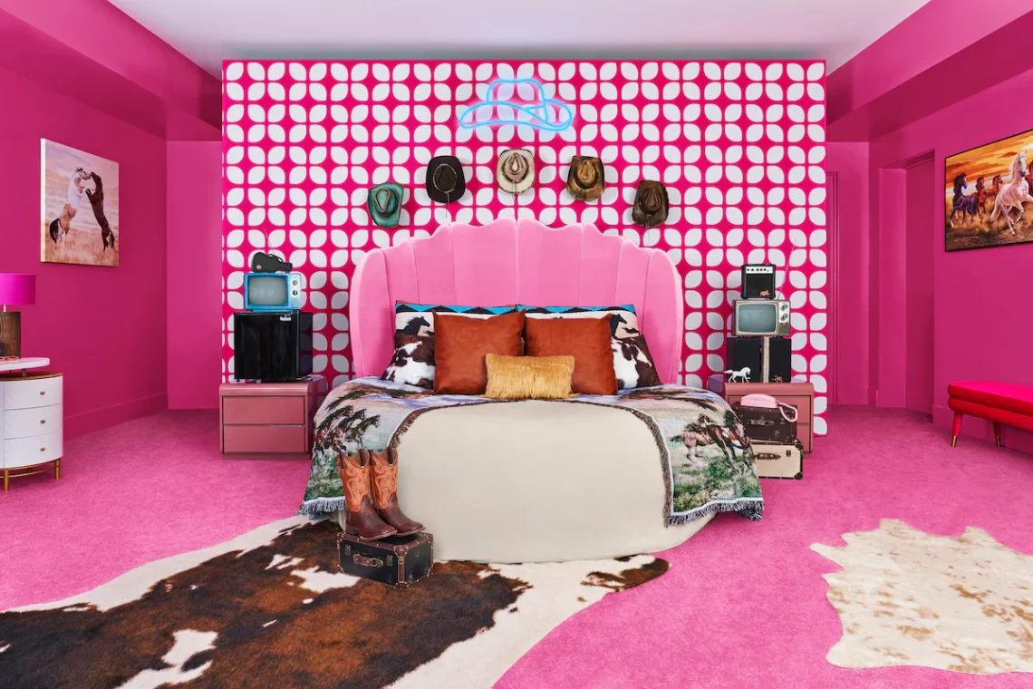 Bold pink bedroom interior with cowhide accents, patterned wallpaper, and eclectic decor elements.