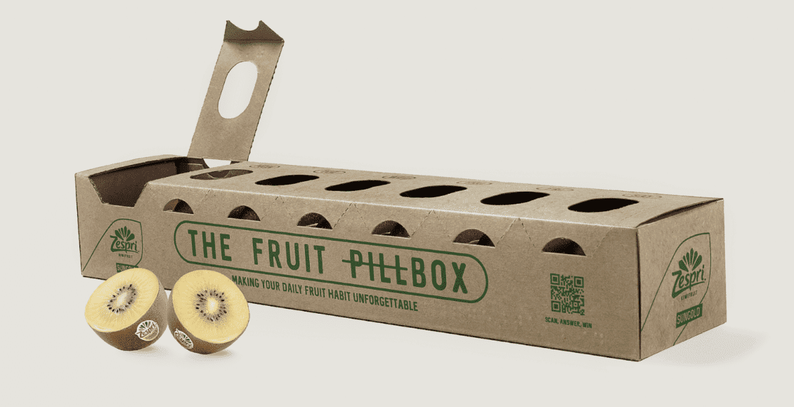 Eco-friendly cardboard fruit packaging box labeled "The Fruit Pilebox" with two halves of a kiwi fruit in front.