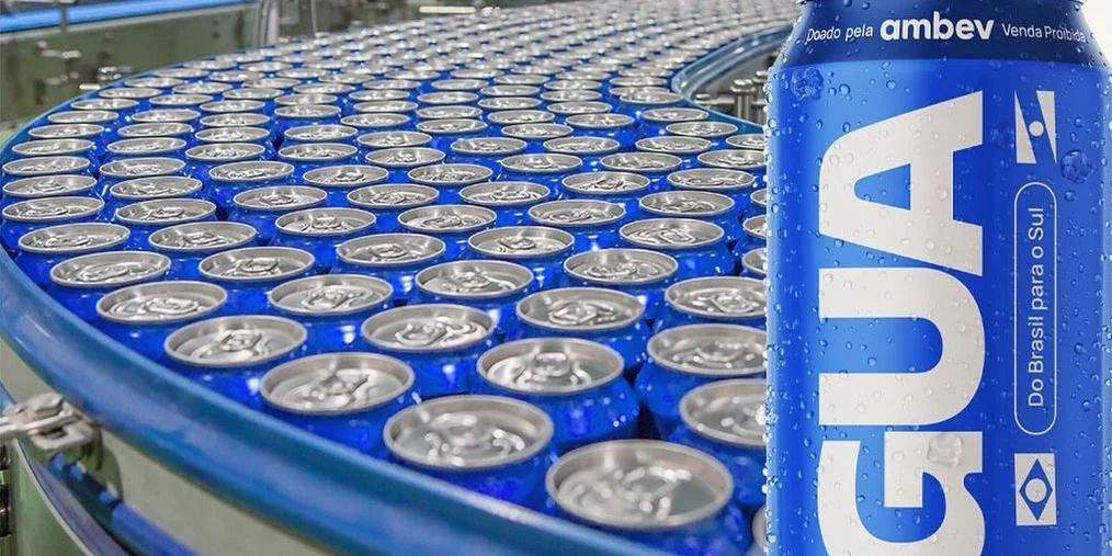 Beverage production line with conveyor belt full of aluminum cans for drinks, close-up of a single can in focus with condensation droplets.